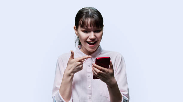 istock Surprised young female looking at smartphone on white background 1466685728