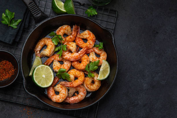 spicy roasted shrimps in cast iron pan stock photo