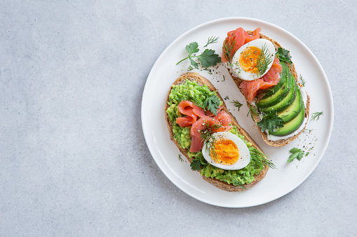 toasts with avocado, smoked salmon and egg , top view