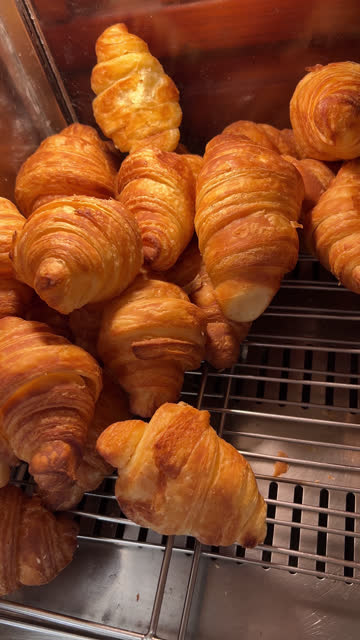 Fresh croissants close up view. Delicious French breakfast. Baked croissants. Puff pastry, croissants, puffs. Food industry, confectionery, bakery. Knead, roll out the dough at a large production