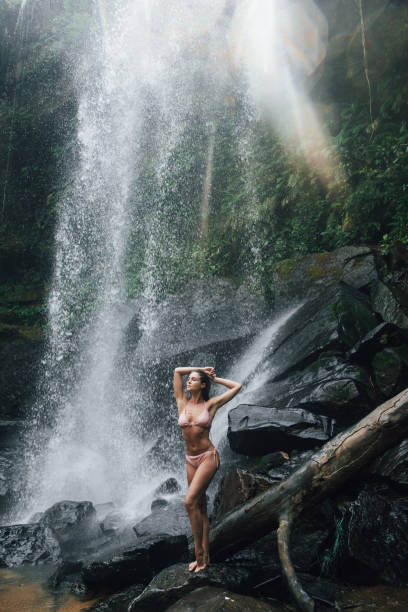 istock Gorgeous wet woman posing beside mighty Phnom Kulen waterfall 1466691470