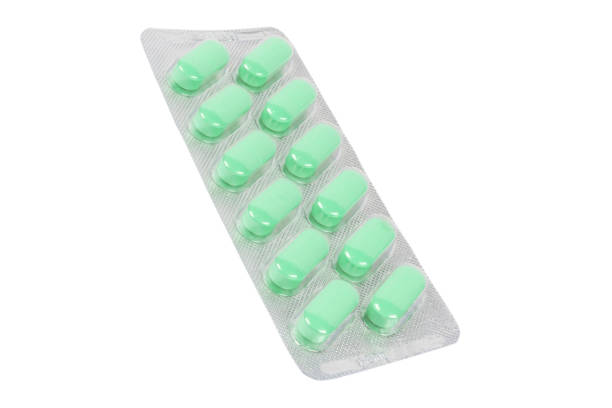 istock Macro shot pile of green tablets pill in blister packaging isolated on white background. Aluminium foil blister pack. Medicine pills and drugs close up. Health care. Pills background 1466692995