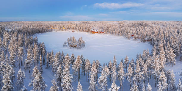 Aerial winter landscape in Sweden Panoramic aerial view of a snowy forest and the frozen lake with mountain chalets, Lapland, Sweden swedish sauna stock pictures, royalty-free photos & images