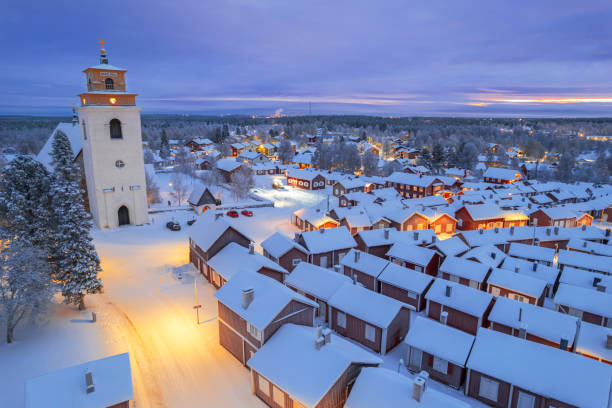 Gammelstad Church Town at dusk, aerial winter view, Sweden Illuminated winter aerial view of the old medieval village of Lulea with snow on top of the cottages, UNESCO world heritage site, Gammelstad, Lulea, Norrbotten, Sweden norrbotten province stock pictures, royalty-free photos & images