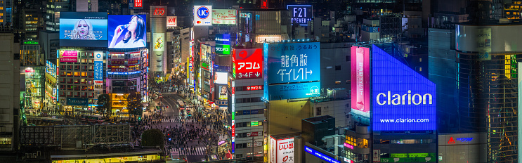 Aerial view over the iconic Shibuya Crossing and the crowds of commuters and shoppers on the streets below the colourful neon signs in the heart of Tokyo, Japan’s vibrant capital city.