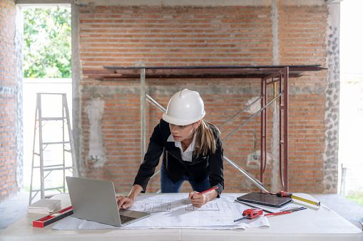 Caucasian female architect working on construction site.