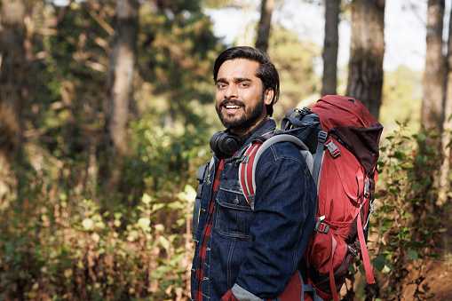 Portrait Young India man backpack smile in forest