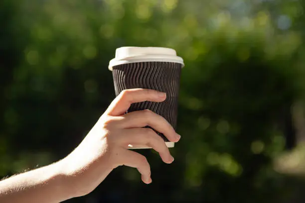 Closeup photography of woman hand.holding cup of coffee in the hand.Place for logo.