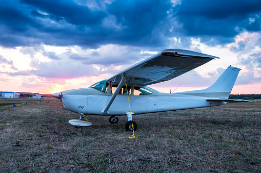 Small private aircraft parked at the airfield at scenic sunrise