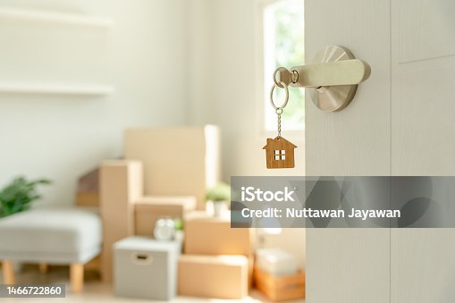 istock Moving house, relocation. The key was inserted into the door of the new house, inside the room was a cardboard box containing personal belongings and furniture. move in the apartment or condominium 1466722860