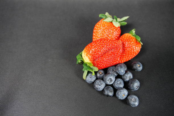 Baskets of ripe, juicy strawberries and  blueberries at a farm stand on Cape Cod.
