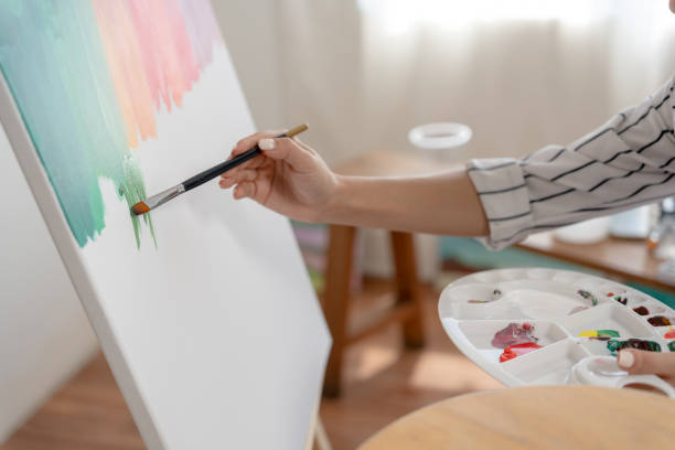 istock female hobbies about artist and use paintbrush in abstract art for create masterpiece. painter paint with watercolors or oil in studio house. enjoy painting as hobby, recreation, inspiration 1466723648