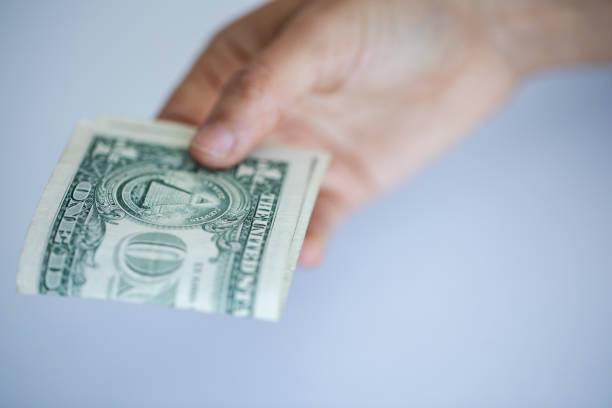 istock person holding a dollar bill 1466726285