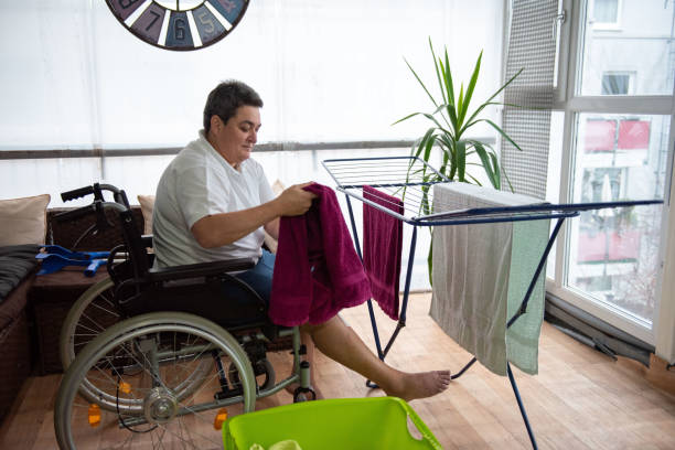 a disabled person on a wheelchair washes laundry. stock photo