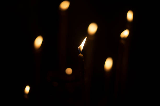 istock Candles burn in dark. Candle lights. Flames on black background. 1466728801