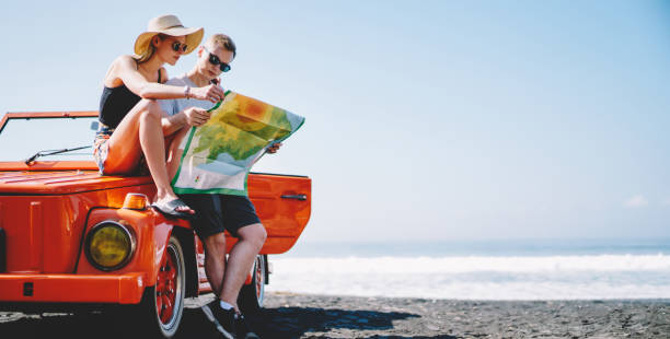 istock Stylish couple looking at map near car 1466729350