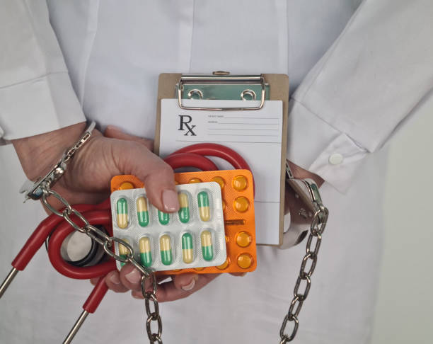 医師は手錠をかけられた手に処方薬を持つ - crime medicine narcotic rx ストックフォトと画像
