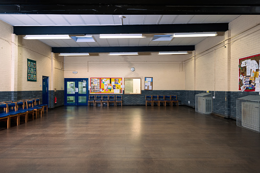 Wide shot of an empty community centre with wooden flooring and notice boards to the right and middle of the frame. The community centre is located in Seaton Deleval in the North East of England.