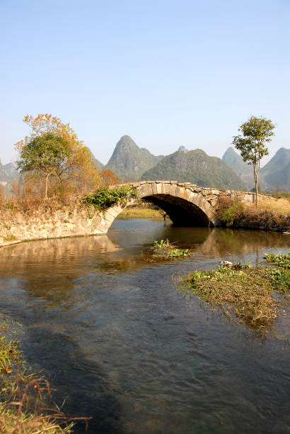 eine alte steinbrücke in der nähe von yangshuo, china - bridge beauty in nature travel destinations yangshuo stock-fotos und bilder