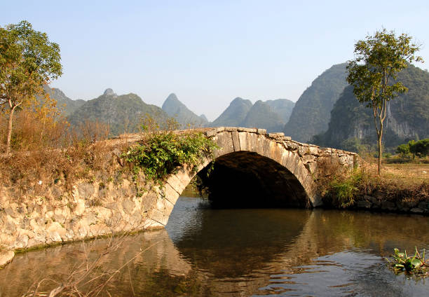 uma ponte de pedra antiga perto de yangshuo, china - bridge beauty in nature travel destinations yangshuo - fotografias e filmes do acervo