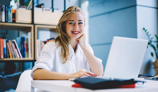 istock Smiling woman with laptop in workspace 1466736081
