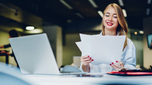 istock Positive female freelancer working with documents and laptop 1466736205