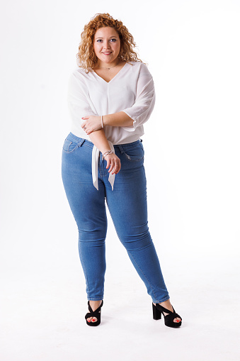Plus size fashion model in denim clothes and white shirt on white background, overweight female body