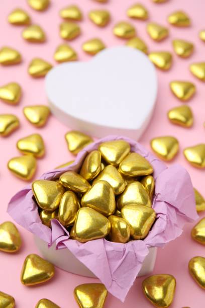 istock Box and delicious heart shaped candies on pink background 1466742093