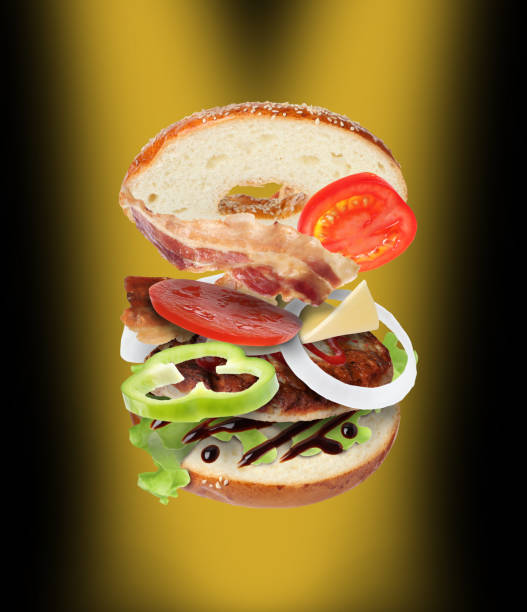 istock Tasty cut bagel with different ingredients flying on color background 1466743108
