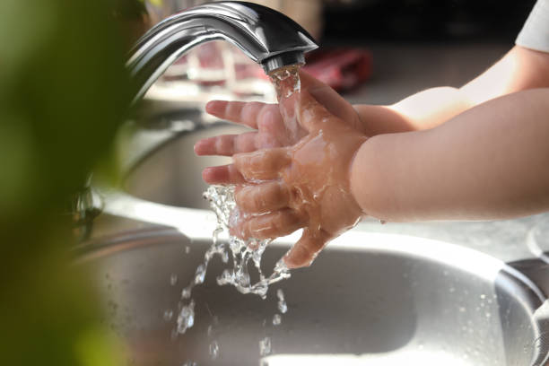 istock Little child washing hands in kitchen, closeup view 1466744592
