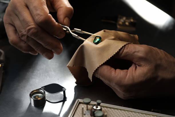 Professional jeweler working with gemstone at table, closeup Professional jeweler working with gemstone at table, closeup emerald gemstone stock pictures, royalty-free photos & images