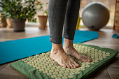 Mature woman exercising against flat feet at home