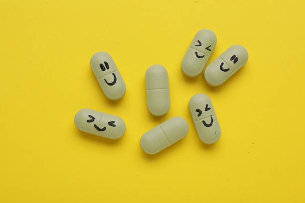 istock Colorful antidepressants with happy emoticons on yellow background, flat lay 1466748361