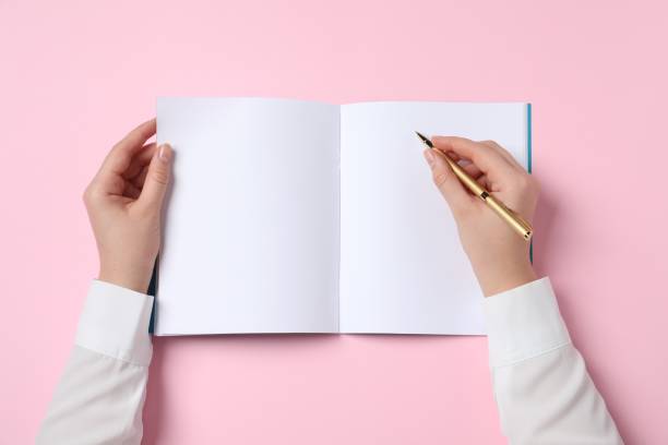 istock Woman with pen and notepad on pink background, top view 1466748623