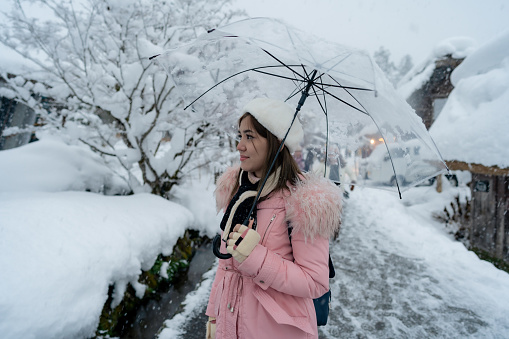 Woman travel at Shirakawa-go village with white thick snowing, the best for tourist travelling in Japan at winter.