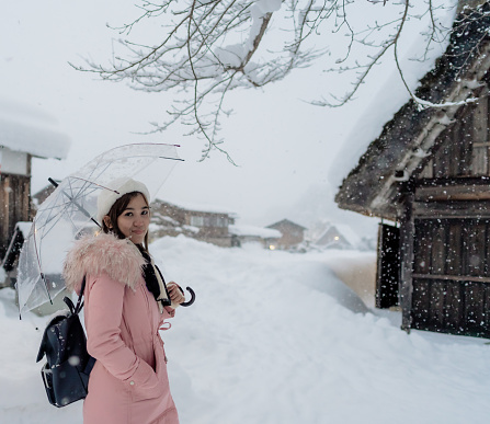 Woman travel at Shirakawa-go village with white thick snowing, the best for tourist travelling in Japan at winter.