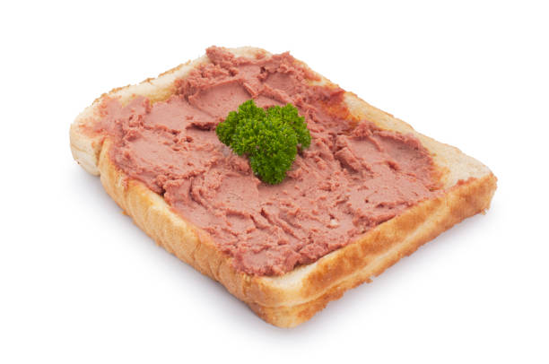 Studio shot of chicken liver pate spread on white toast cut out against a white background