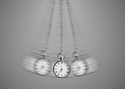 Hypnosis session. Vintage pocket watch with chain swinging on grey background, motion effect