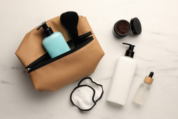 istock Preparation for spa. Compact toiletry bag and different cosmetic products on white marble table, flat lay 1466751071