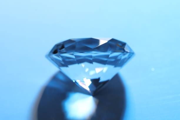 istock Beautiful dazzling diamond on blue background, closeup 1466751190