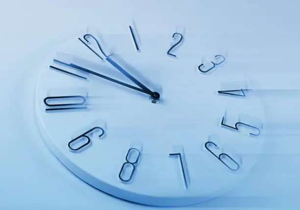Fleeting time concept. Clock on light blue background, motion effect