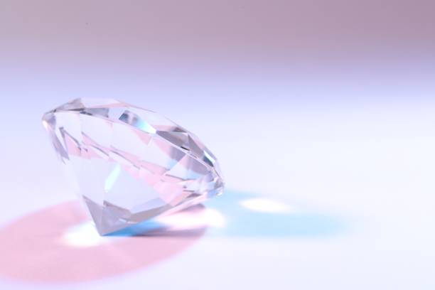 istock Beautiful dazzling diamond on color background, closeup. Space for text 1466751881