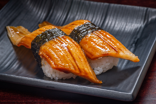 Japanese style of sushi with eel fish on black plate, Asian food, traditional Japanese food.