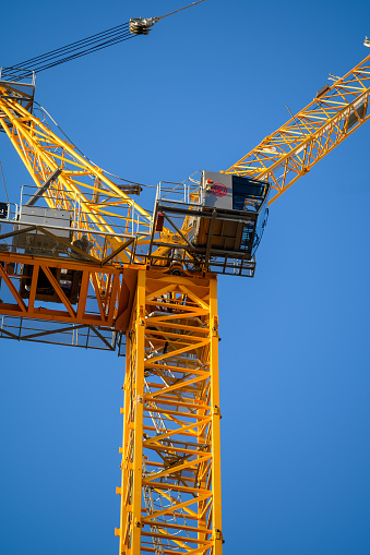 LONDON - November 2, 2020: Close up of cab on large yellow construction crane against a clear blue sky