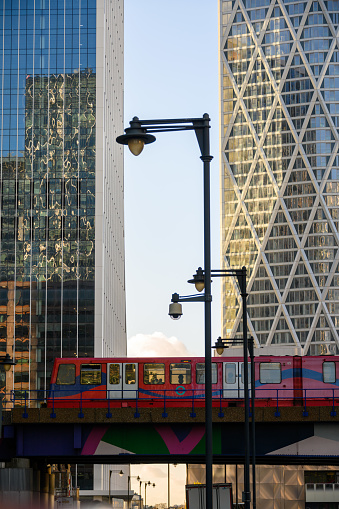 Docklands Light Railway DLR train crosses bridge in front of modern glass office buildings