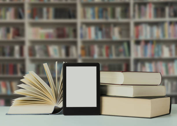 istock Hardcover books and modern e-book on table in library 1466757872