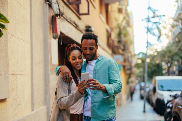 istock African American couple using mobile phone outside. 1466759505