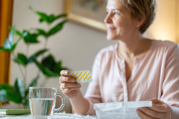 A smiling woman is relieved to get her HRT pills stock photo