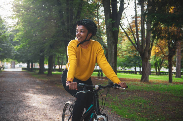 istock Confident female athlete riding bicycle in public park 1466765752