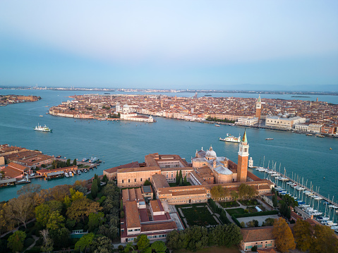 Aerial shot of islands with famous Church of San Giorgio Maggiore and St Mark's Campanile surrounded with lagoon against sky in Venice,Italy